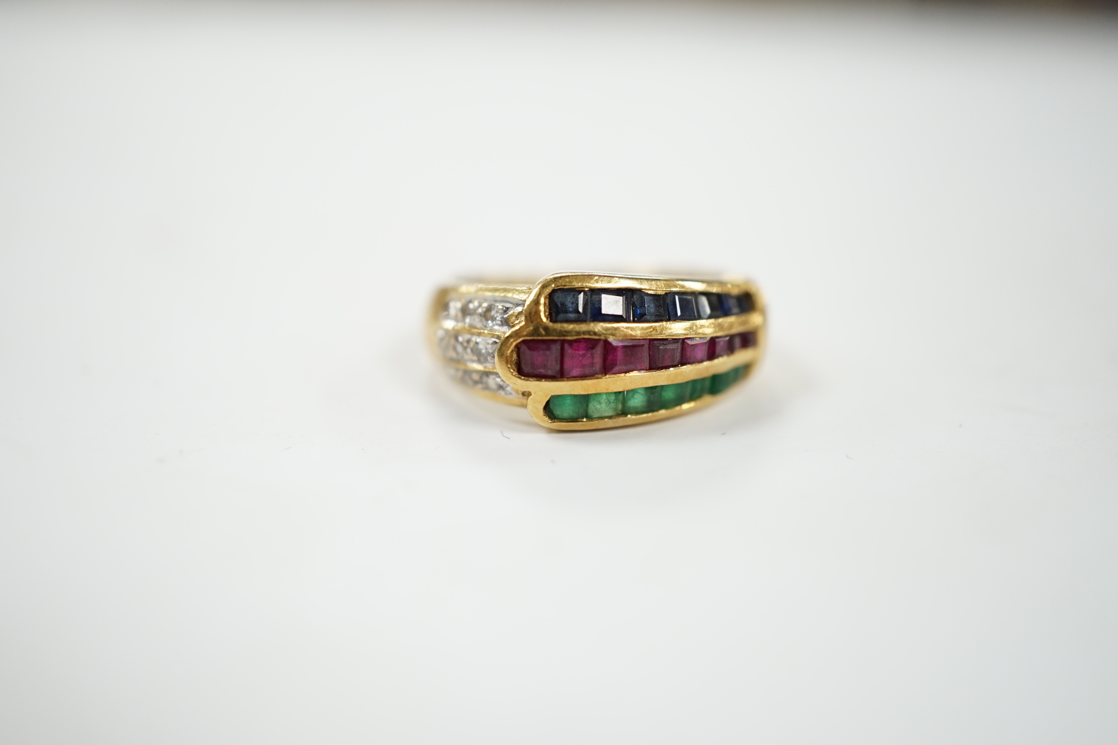 A modern 750, ruby, emerald, sapphire and diamond chip set three row ring, size I, gross weight 4.8 grams.